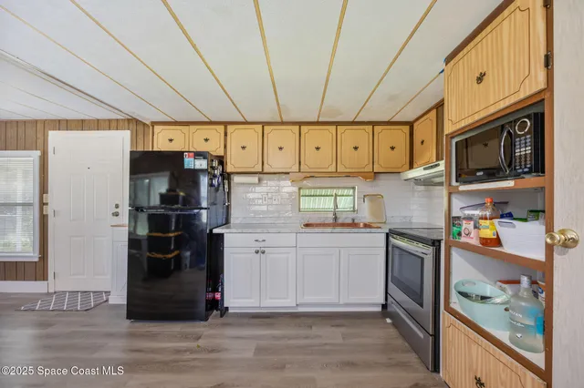 a kitchen with stainless steel appliances granite countertop a refrigerator and a stove top oven