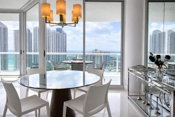 a dining room with furniture and a floor to ceiling window