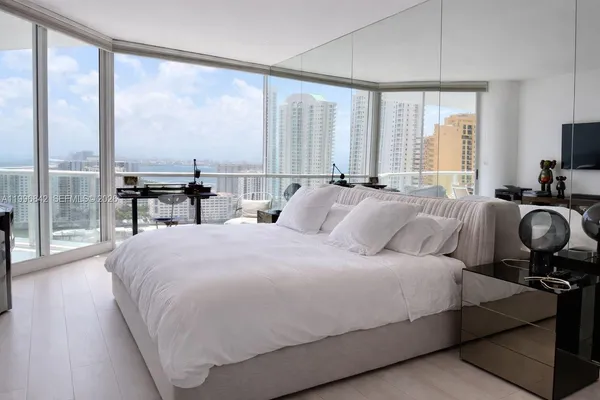 a large bedroom with a bed and large window