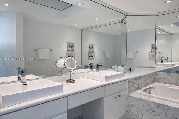 a bathroom with a sink double vanity tub and mirror