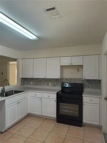 a kitchen with a stove sink and cabinets