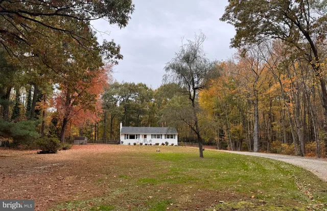 a front view of a house with a yard and trees