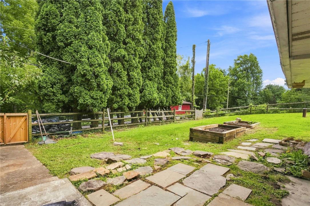 3408 Oak Hill Road Emmaus, PA 18049 - Photo 35 of 93 A spacious grassy lawn features flagstone accents, wooden garden beds, and mature perimeter trees.