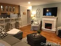 a room with stainless steel appliances a dining table wooden floor and a large window