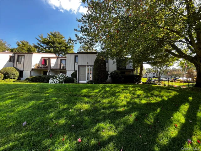a front view of a house with a yard and trees