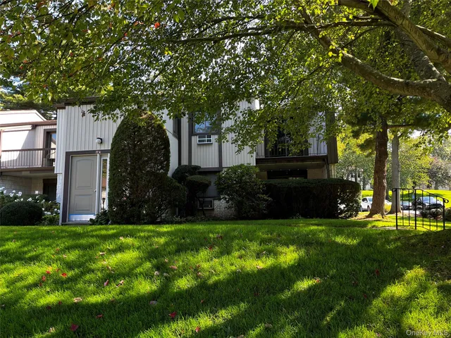 a view of a house with a big yard and large trees