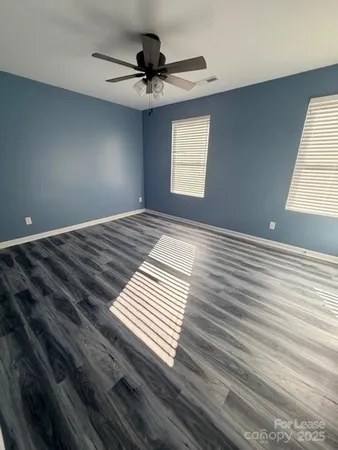 a view of a room with a ceiling fan and window