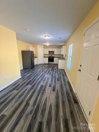 a open kitchen with wooden floor and outdoor space