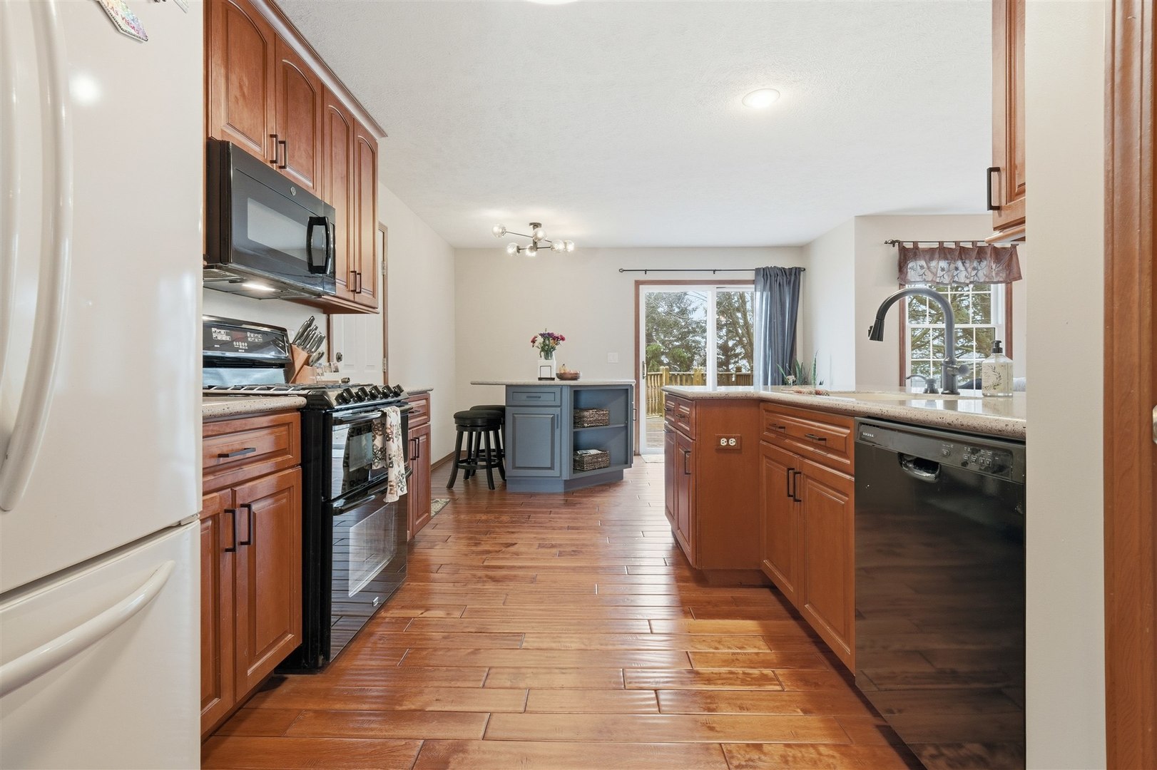 811 Landau Lane Normal, IL 61761 - Photo 5 of 34 a kitchen with stainless steel appliances granite countertop a stove top oven a sink a dining table and chairs with wooden floor