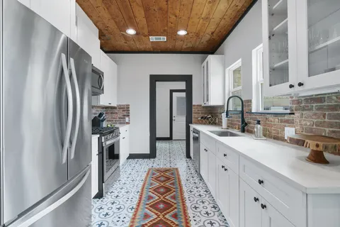 a large kitchen with stainless steel appliances a refrigerator sink and cabinets
