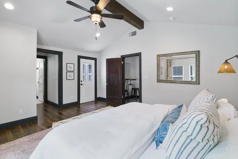 a bedroom with a large bed and a chandelier