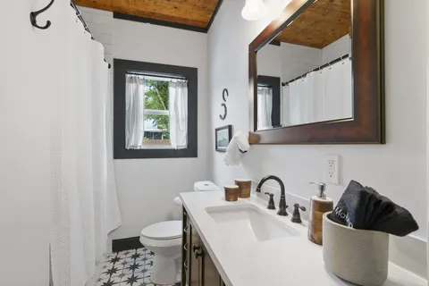 a bathroom with a toilet a sink and mirror