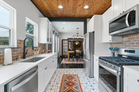 a kitchen with stainless steel appliances a stove a sink and a microwave
