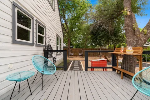 a balcony with wooden floor table and chairs