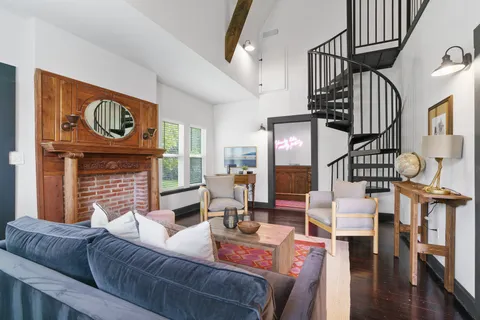 a living room with furniture a fireplace and wooden floor