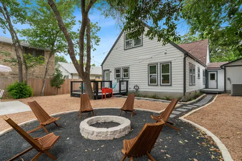 a backyard of a house with fire pit and outdoor seating