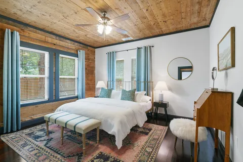 a bedroom with a bed mirror and window