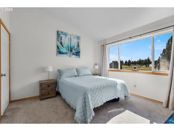 a bedroom with a bed and a large window