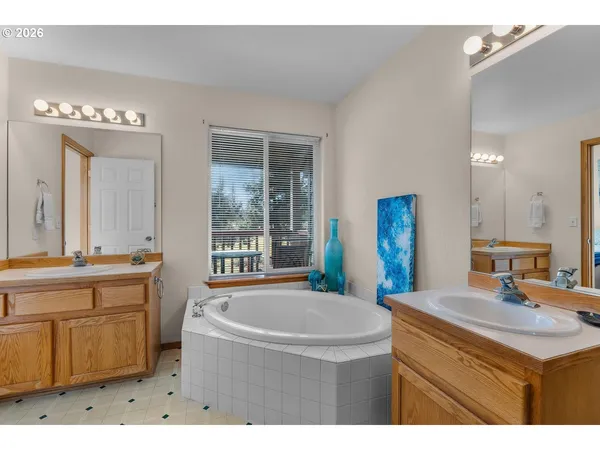 a bathroom with a tub sink and mirror