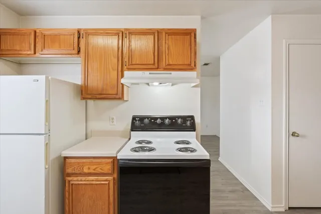 a kitchen with a stove a refrigerator and a window