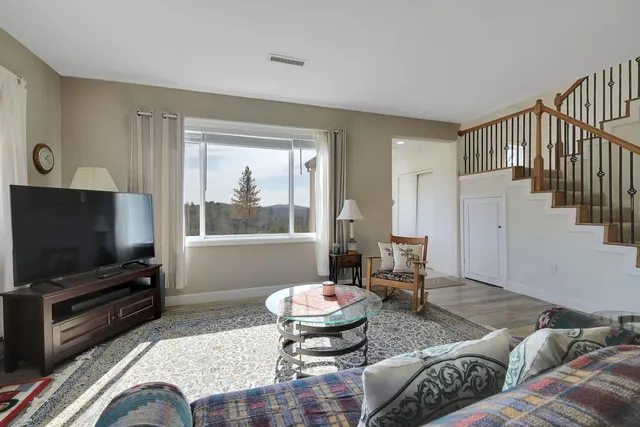 a kitchen with stainless steel appliances granite countertop a sink dishwasher a stove and a refrigerator with wooden floor