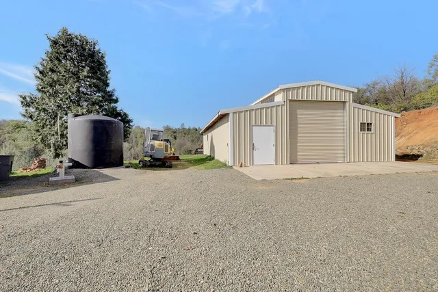 a view of a dining room and livingroom with furniture wooden floor a rug a fireplace
