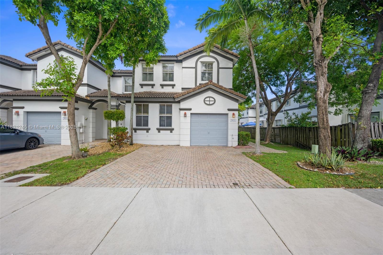 7633 Northwest 114th Path, Unit 7633 Doral, FL 33178 - Photo 1 of 25 a front view of a house with a yard and garage