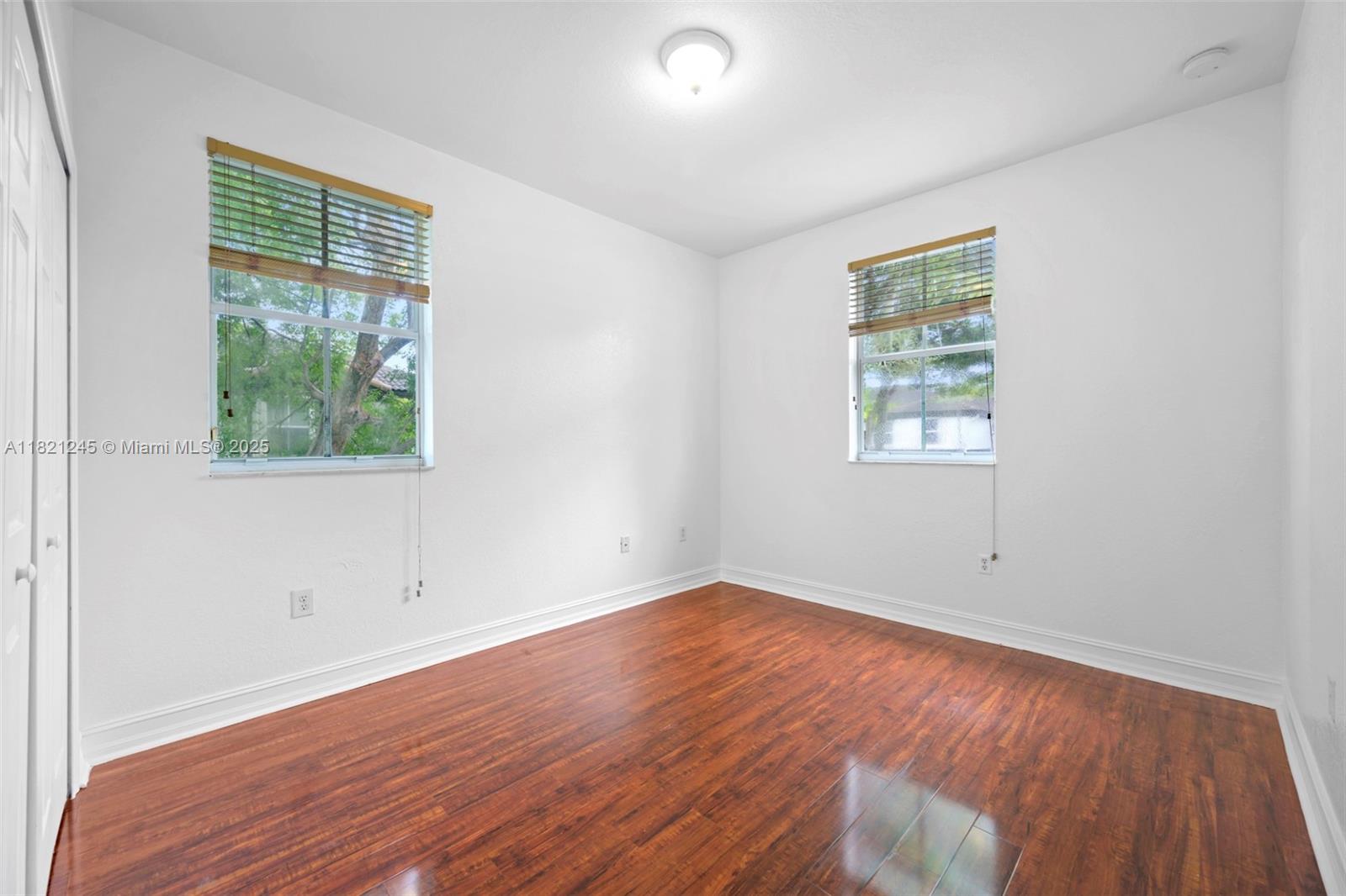 7633 Northwest 114th Path, Unit 7633 Doral, FL 33178 - Photo 17 of 25 an empty room with wooden floor and windows