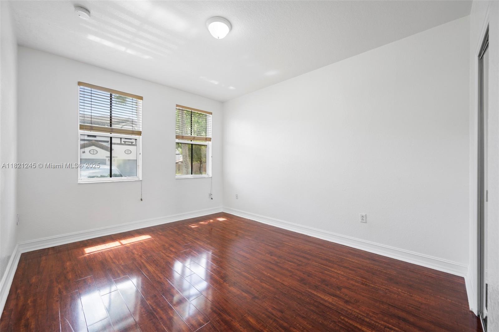 7633 Northwest 114th Path, Unit 7633 Doral, FL 33178 - Photo 7 of 25 an empty room with wooden floor and windows