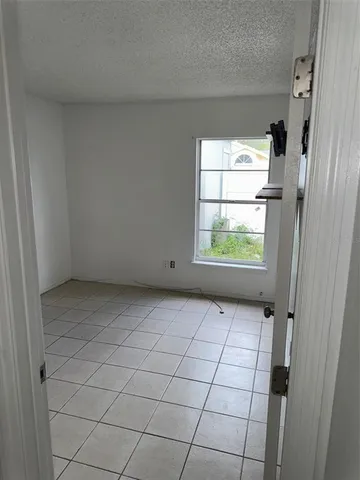 a view of a hallway with wooden floor and cabinets