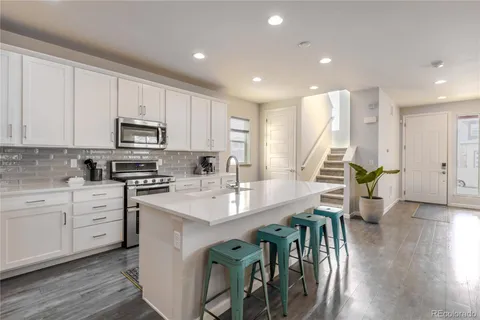 a kitchen with stainless steel appliances white cabinets and a sink
