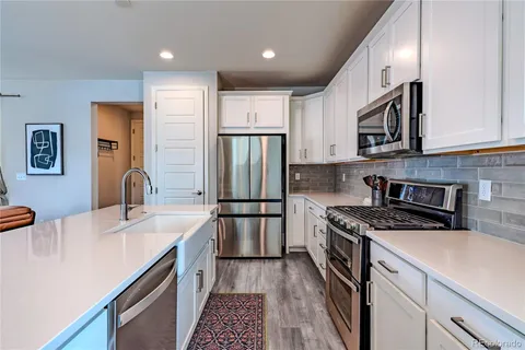 a living room with furniture kitchen view and a large window