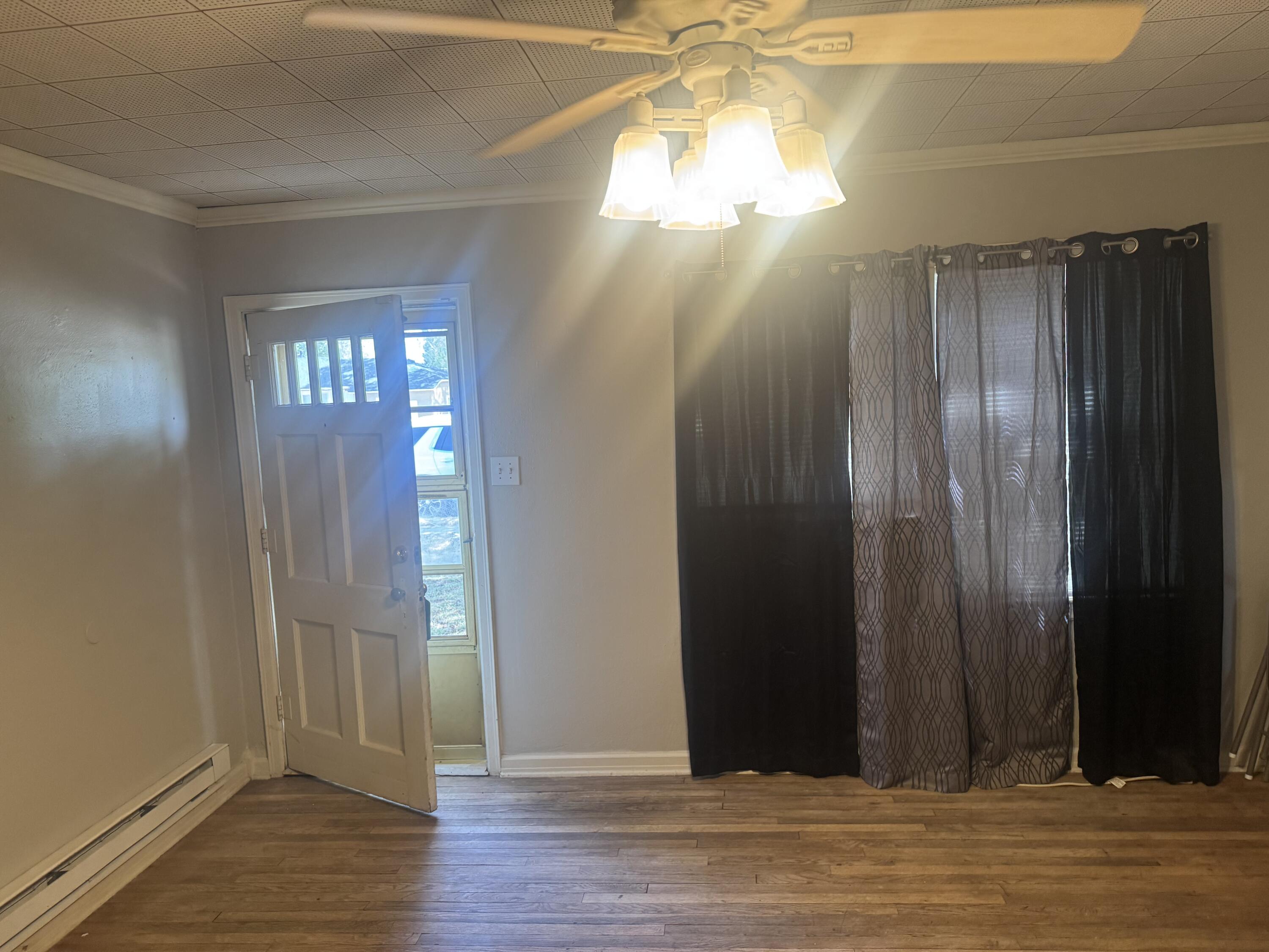 2612 36th Street Lubbock, TX 79413 - Photo 4 of 30 an empty room with wooden floor door and windows