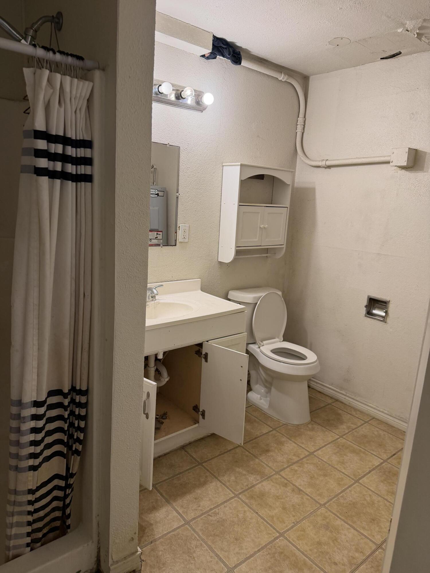 2612 36th Street Lubbock, TX 79413 - Photo 8 of 30 a bathroom with a sink a toilet and shower