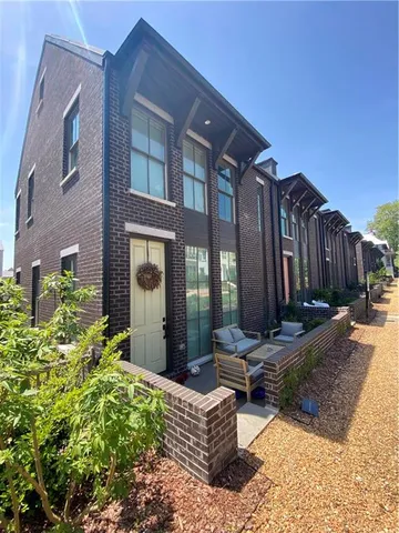 a view of a building with potted plants and wooden fence