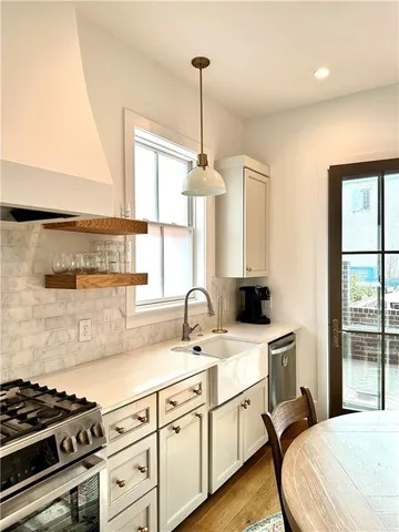 a metallic refrigerator freezer and a stove sitting inside of a kitchen