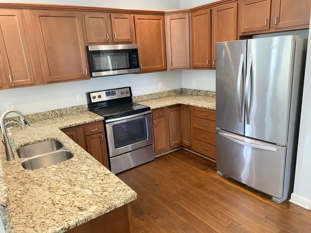 a kitchen with granite countertop a sink stove and refrigerator