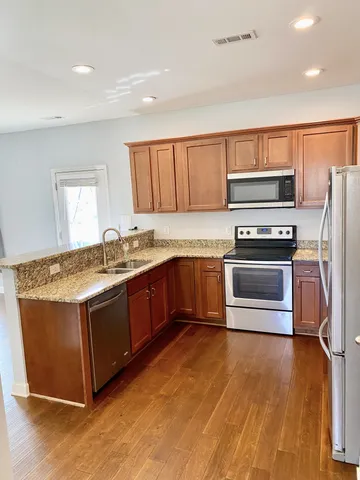a kitchen with granite countertop a stove and a refrigerator