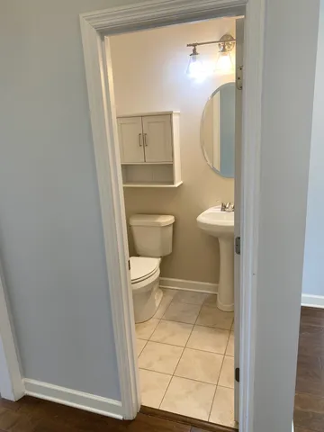 a bathroom with a toilet a sink and mirror