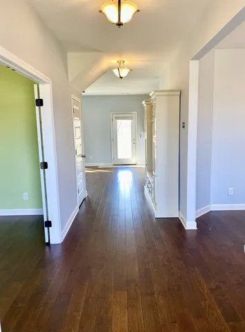 an empty room with wooden floor and a window