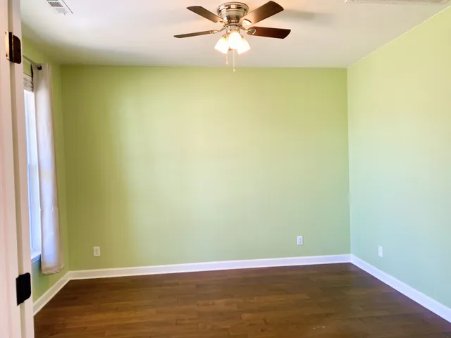 a view of a room with wooden floor and a window