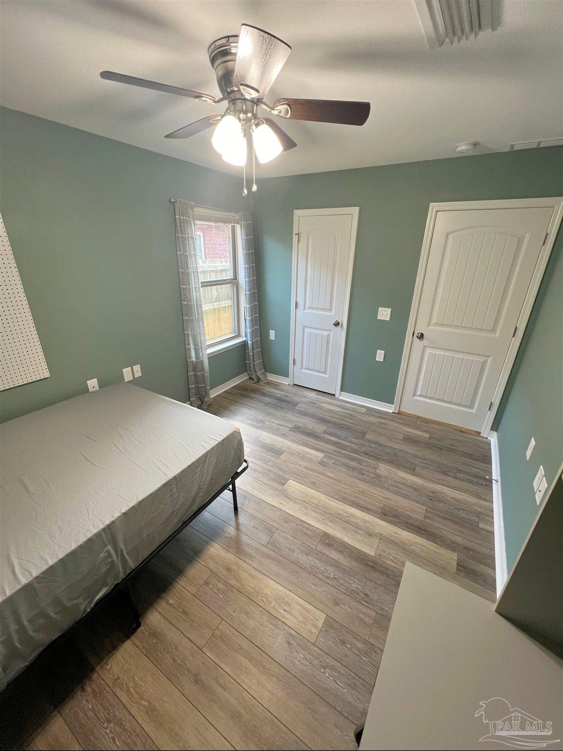 5798 Corkscrew Court Pace, FL 32571 - Photo 11 of 18 a bedroom with a large bed and a chandelier