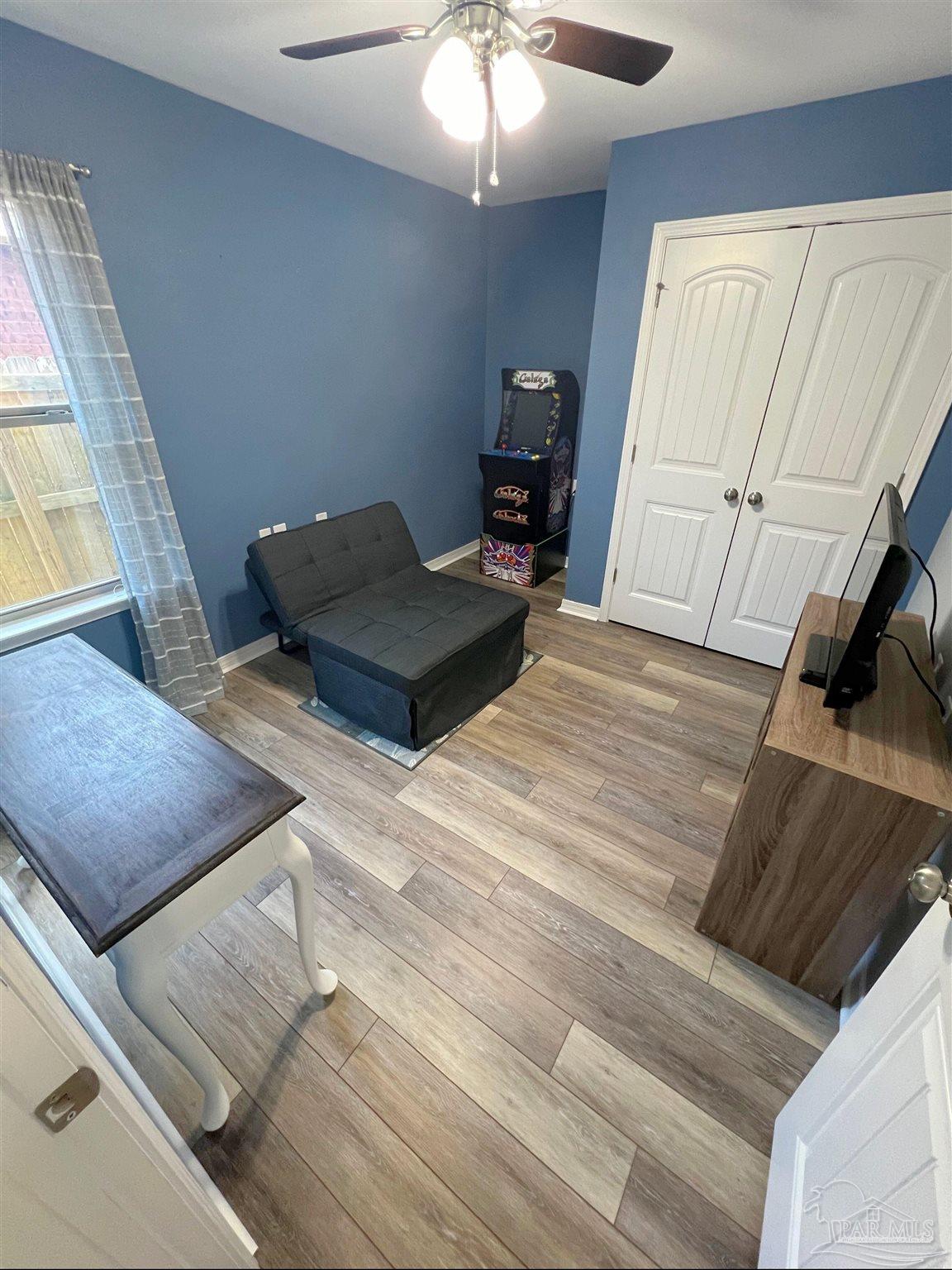 5798 Corkscrew Court Pace, FL 32571 - Photo 12 of 18 a bedroom with a bed and wooden floor