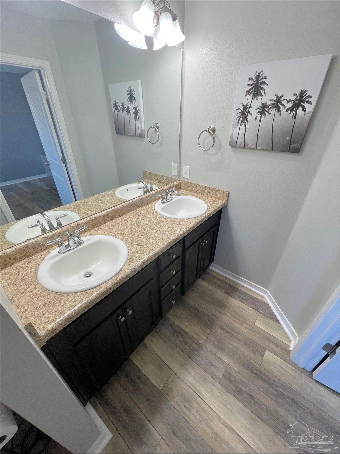 5798 Corkscrew Court Pace, FL 32571 - Photo 14 of 18 a bathroom with a granite countertop sink a mirror and vanity