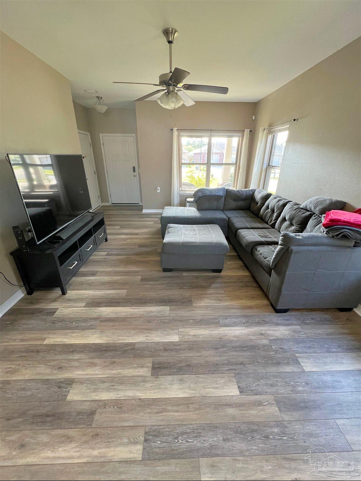 5798 Corkscrew Court Pace, FL 32571 - Photo 4 of 18 a living room with furniture and a flat screen tv