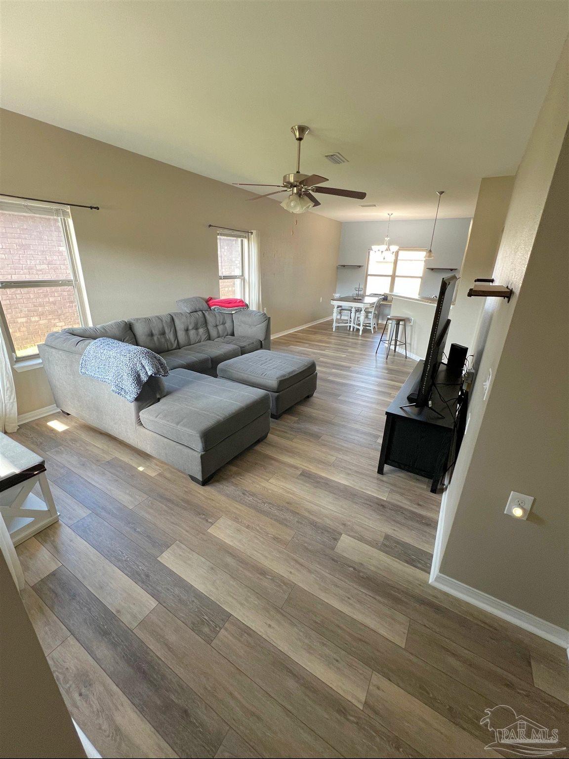 5798 Corkscrew Court Pace, FL 32571 - Photo 6 of 18 a living room with furniture and a wooden floor