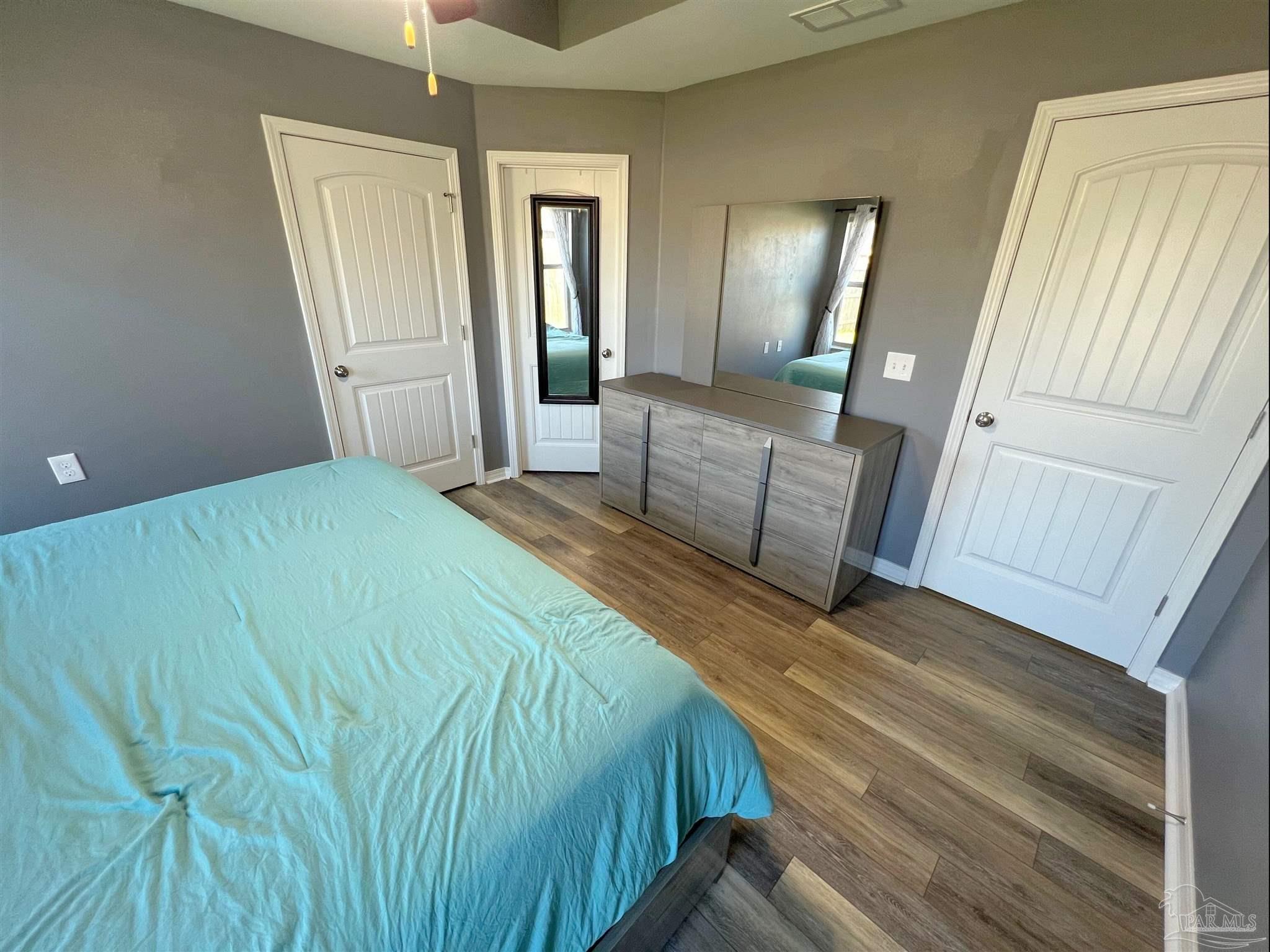 5798 Corkscrew Court Pace, FL 32571 - Photo 8 of 18 a bedroom with a bed and mirror
