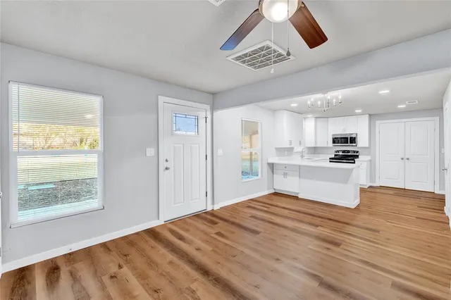 a view of kitchen with kitchen island wooden floor center island and stainless steel appliances