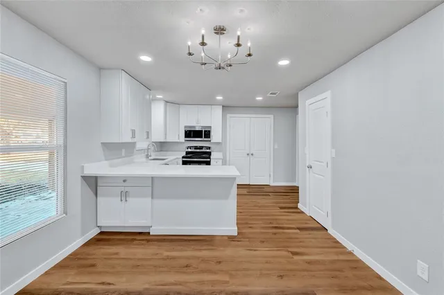a view of kitchen with sink microwave and cabinets