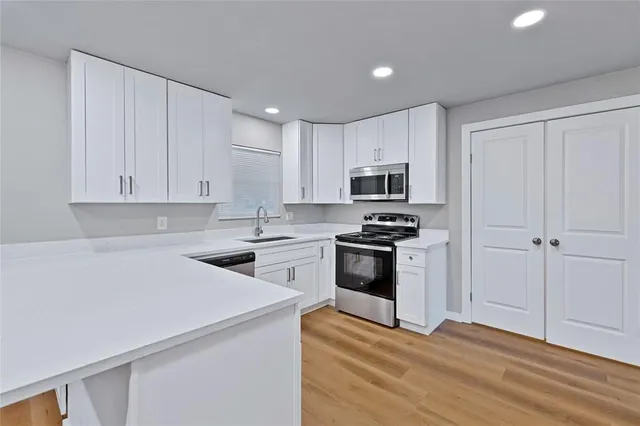 a kitchen with a sink a stove and cabinets
